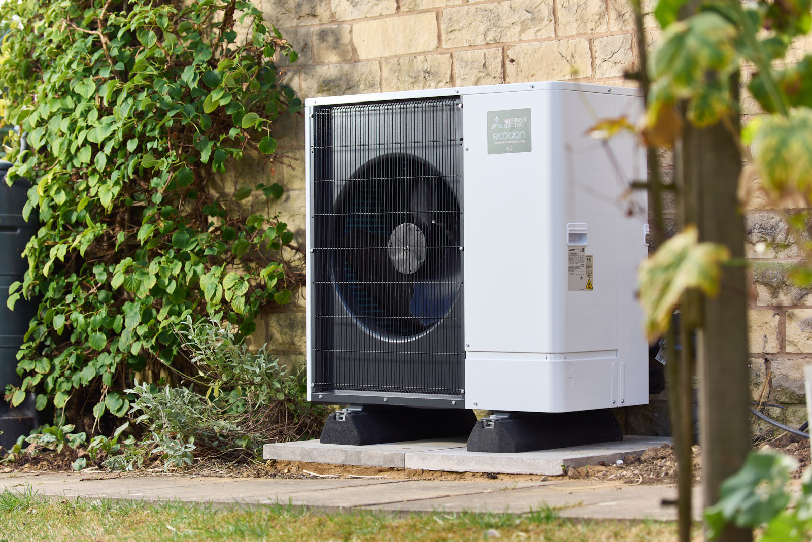 An Air Source Heat Pump next to some leaves