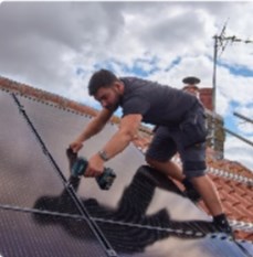a solar panel installer fitting a panel to a roof