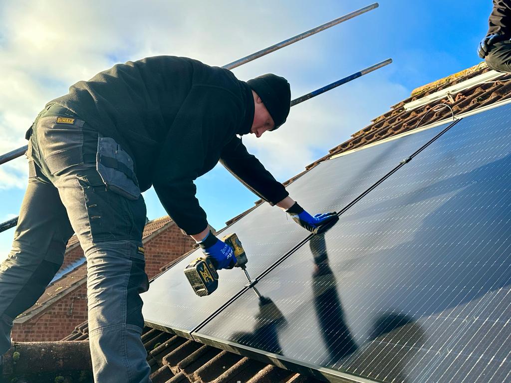 A GBR installer on a roof with solar panels